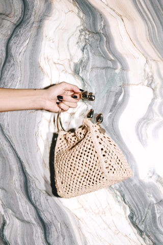 The Natural Quinta Bag held against marble
